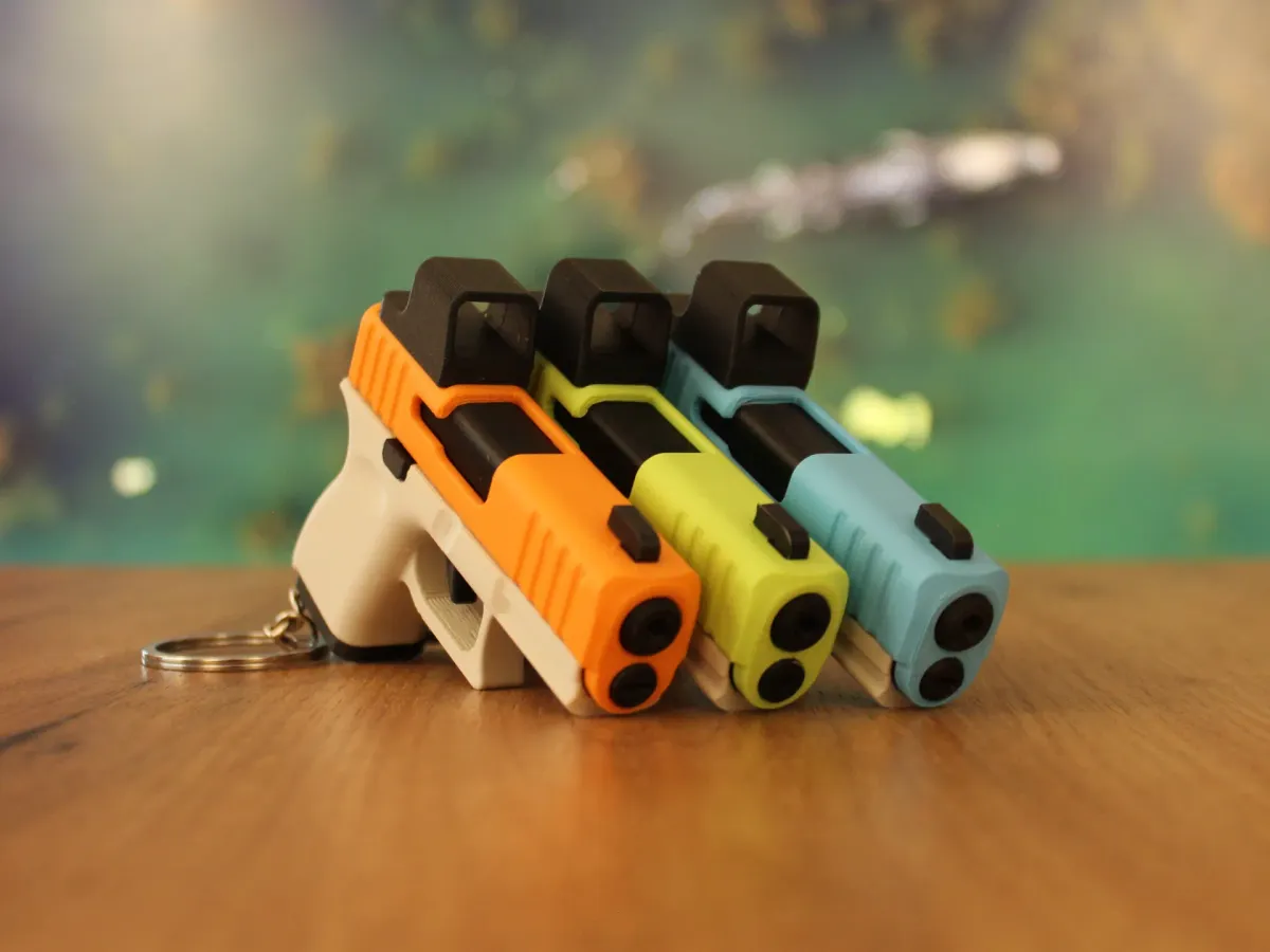 Llavero de pistola de juguete con corredera