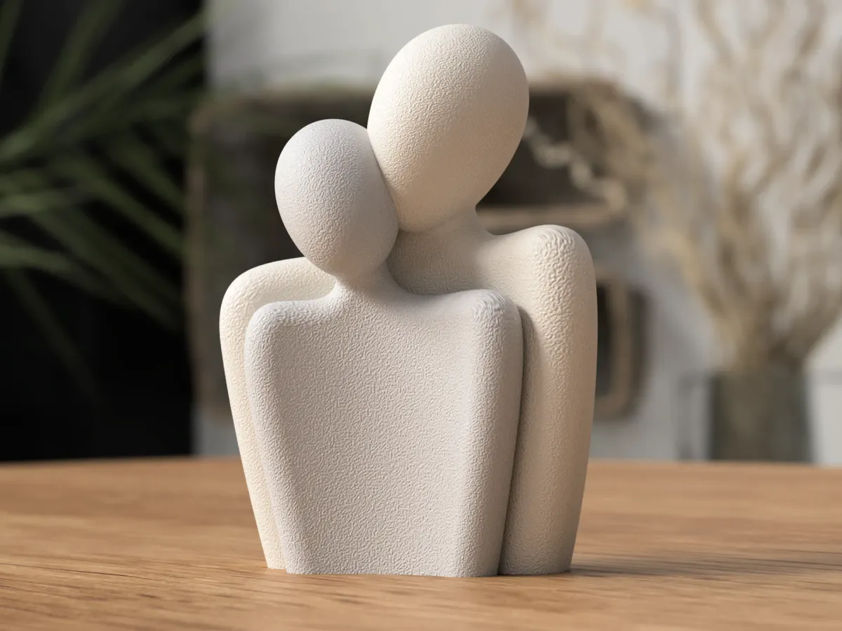 Estatuilla de pareja abrazada sin rostro