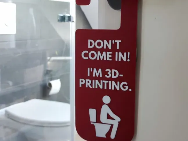 Cartelito de puerta de baño con frase