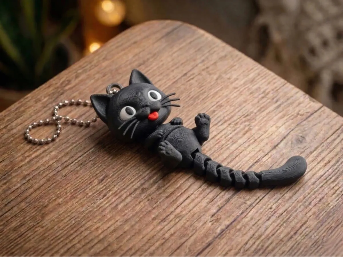 Gatito colgado del borde de la heladera