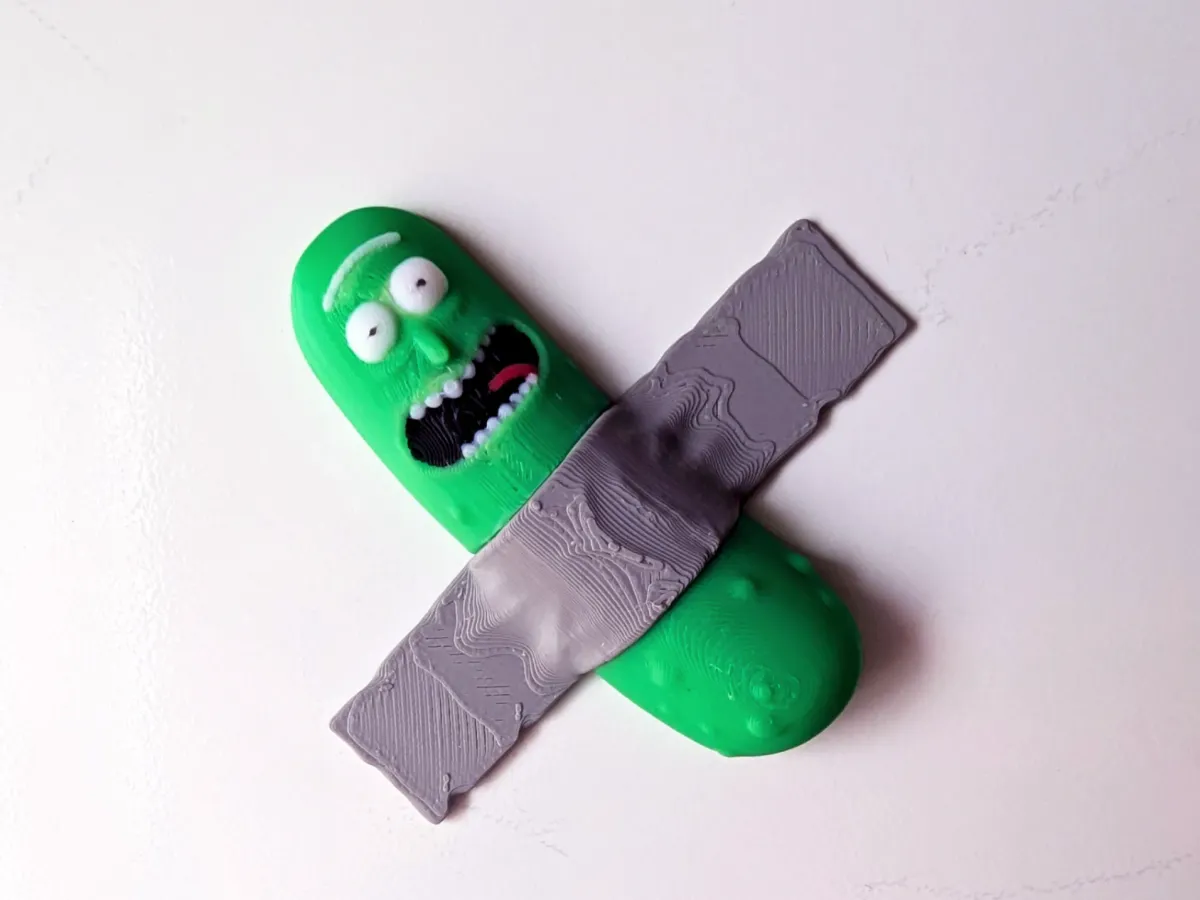 Imán de pepino con cara en relieve