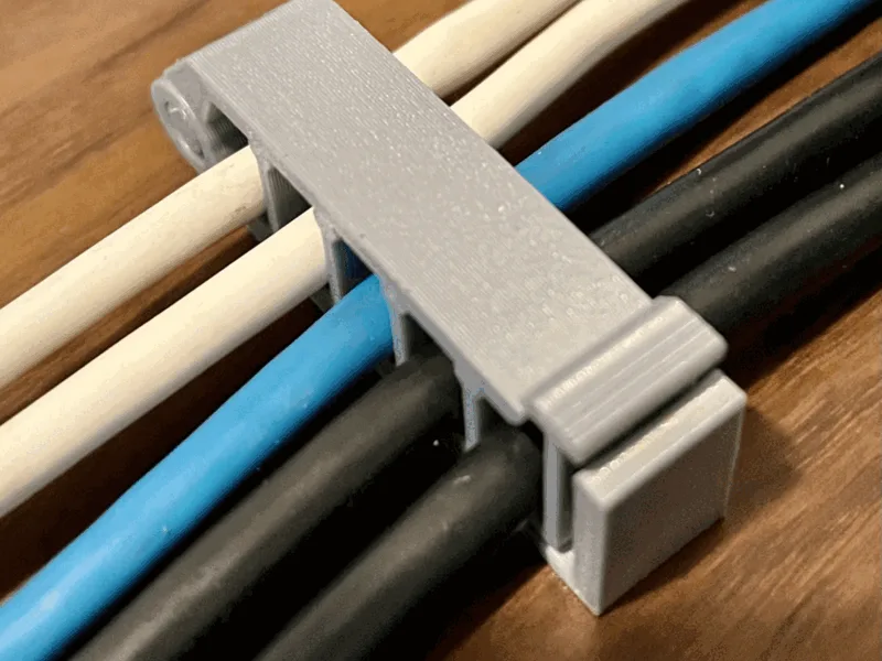 Clip de cable con bisagra que traba