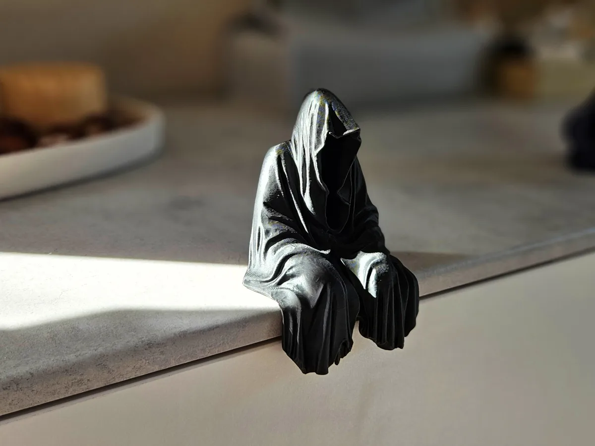 Figura de la muerte sentada en el estante